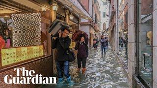 Venice: Tourists and residents wade through flood waters