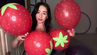 Blowing up strawberry themed balloons