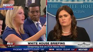 Between reporters, Sarah Sanders at White House press briefing (FNN)