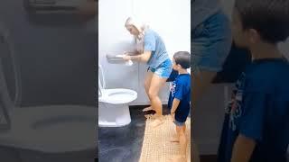 Mom shows son how to use the bathroom 