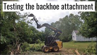 Using the backhoe attachment on the skid steer to take down trees