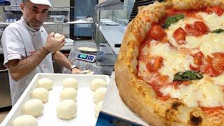 Pizzaiolo Napoletano prepara l'impasto per la Pizza napoletana nella sua pizzeria a Roma 