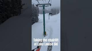 Taking a chair lift as it snows at Lake Louise Ski Resort