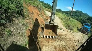 escavadeira tirando pedra gigante de estrada