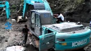 Excavator Kobelco Stuck after being hit by volcanic material