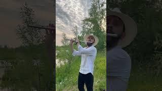 Чувак в странной шляпе играет классику на природе