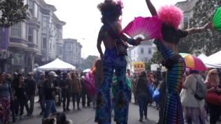 Haight Street Fair women on stilts with flags