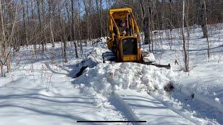 Bulldozer plowing deep hard packed snow