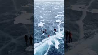 People in the middle of the frozen lake. Ice and Cracks