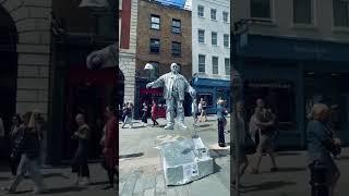 How Silver man statue is levitating his hat ? 