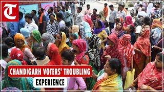 Poll staff restricts entry of voters at a polling station in Chandigarh due to overcrowding