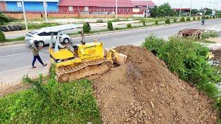 Great action bulldozer skill Komatsu D31P pushing soil filling land with dump trucks