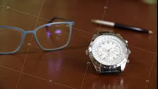 Close up view of wrist watch and eyeglasses on table