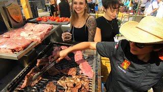 Street Food in Barcelona, Spain. Grilling Hanging Tenderloin Steaks. 'Meat&Fire' Grill Fest