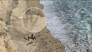 Santa Cruz kite surfer writes HELP in sand
