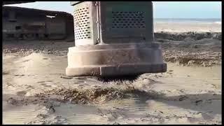 Pulling nails out of a beach bonfire site with a hydraulic scrap magnet.