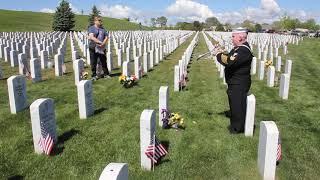 Taps played by trumpet at a military grave in the Fort Logan National Cemetery in Colorado