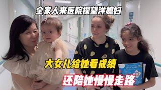 全家人来医院探望洋媳妇，大女儿给她看成绩，还陪她慢慢走路