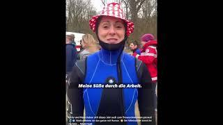 A very happy female TV presenter wearing a blue wetsuit