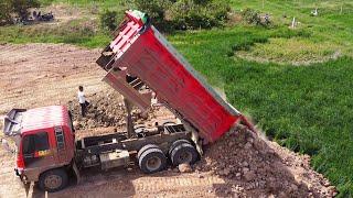 Best teamwork of big dump trucks pouring dirt & Komatsu D31P bulldozer complete filling the land