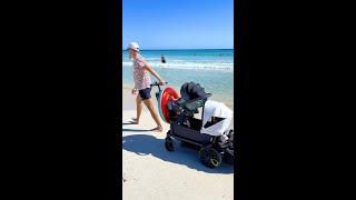 Family walk on the beach using Veer Cruiser and Cybex Cloud Q Car seat