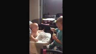 Big brother feeds baby sister for first feeding.