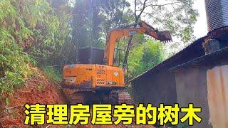 The house is covered with grass, the excavator should clean it up