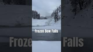 Bow Falls flows down in almost frozen cascades near Banff with a view downriver to Mount Rundle