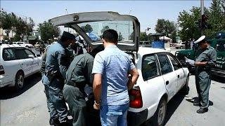 Afghan policemen search passengers at Kabul checkpoint