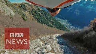 Amazing 'high five' by wingsuit pilot