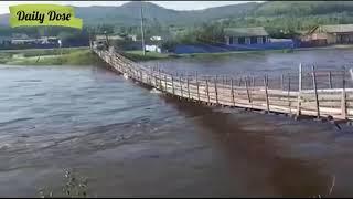 Car trying cross river on a pedestrian wooden bridge