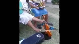 Niño toca el violín con los pies