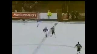 Playing football in the snow with a white ball.