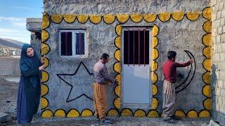 Abbas painting the front of the house with the help of his father