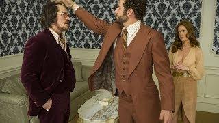 Bradley Cooper messes with Christian Bale's elaborately constructed hair  in "American Hustle."