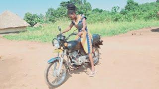 She is learning how to ride a motorcycle // African village life.