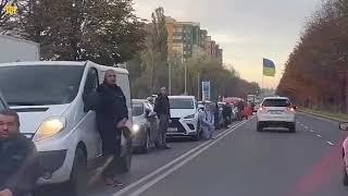 Ukrainians kneel on road as their fallen heroes return home