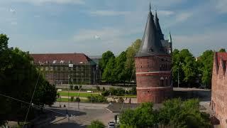 Rise up footage of historic centre of city. Aerial side view of Holsten Gate. Brick Gothic relic of