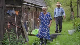Happy old age of an elderly couple in a mountain village in the summer far from civilization