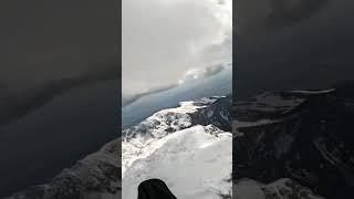 Paragliding over snowy tops and playing with clouds