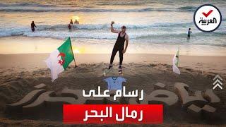 فلسطيني يكتب بالخط العربي على رمال شاطئ بحر غزة