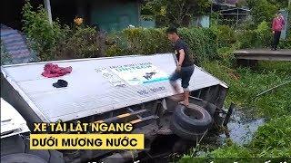 Hú vía xe tải lật ngang dưới mương nước cạnh quốc lộ khiến CSGT khốn khổ