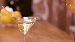 green olives in a glass of martini on a bar counte F5Y6CEG