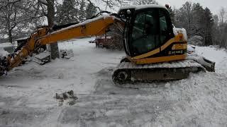 Skotta snö med grävmaskin