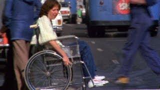 Genni Batterham crossing a busy street in her wheelchair