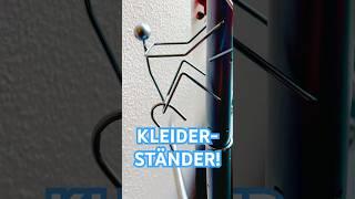 KLEIDERSTÄNDER MIT SCHWINGENDEN KLEIDERBÜGEL ZWISCHEN DEN BEINEN 