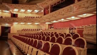 An empty hall in the theater: rows of chairs and beautiful ornaments