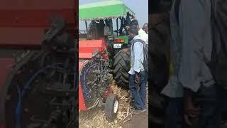 Round baler working in maize field