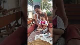 Amos Haokip feeding chickens with his Grandpa