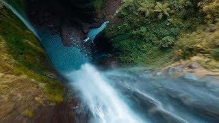 Drone Flies Through Jungle Waterfall